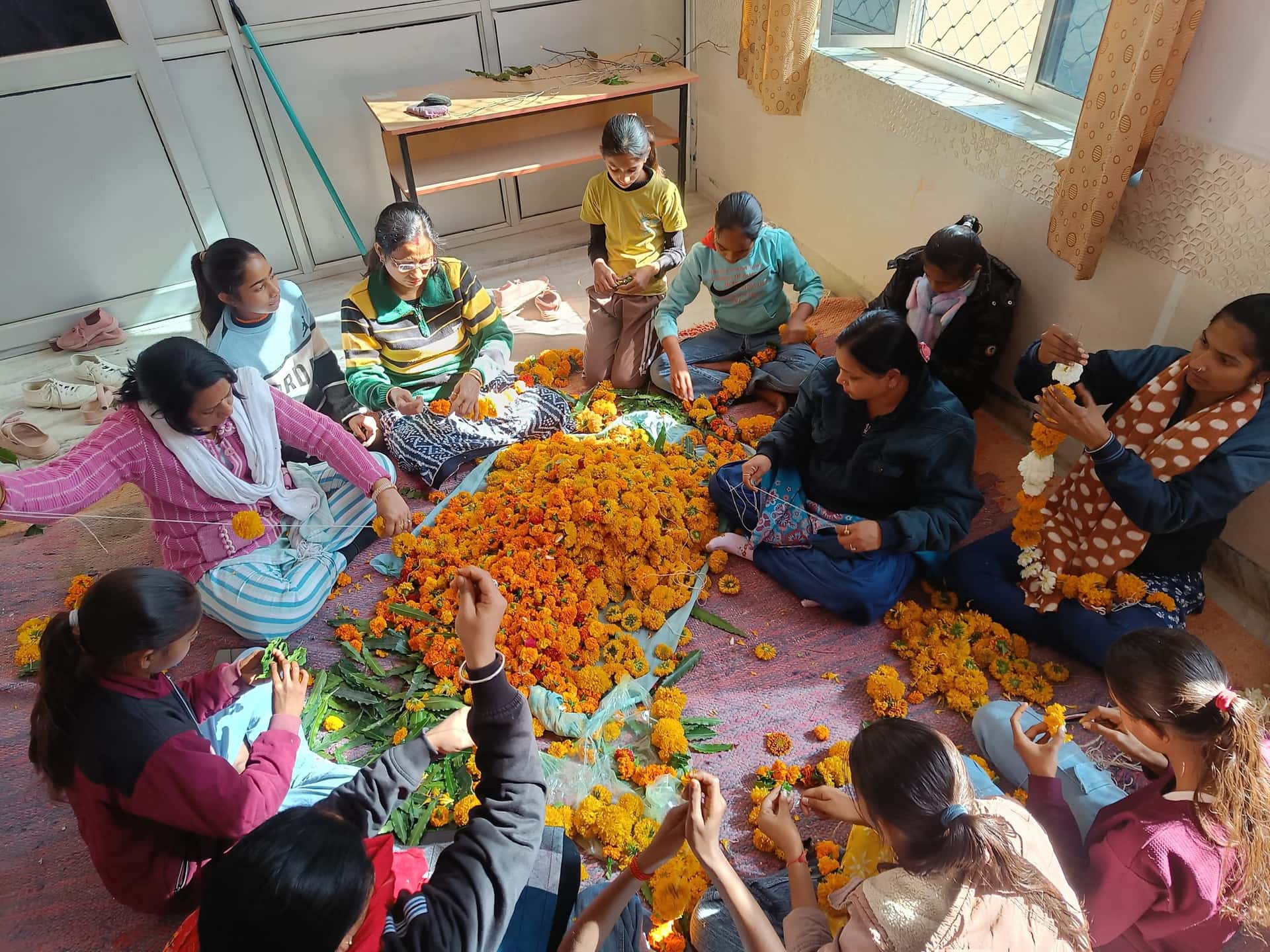 Women preparing marigold garlands for Aarogyam Kendra inauguration